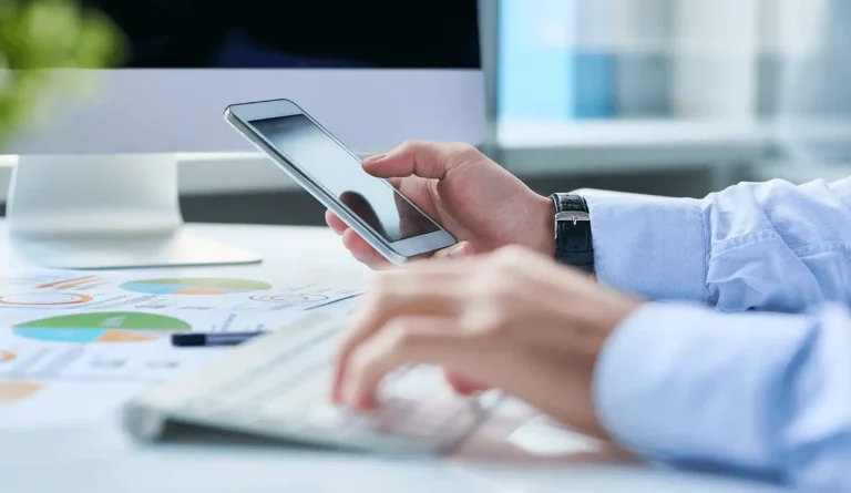 person-at-desk-typing-on-phone