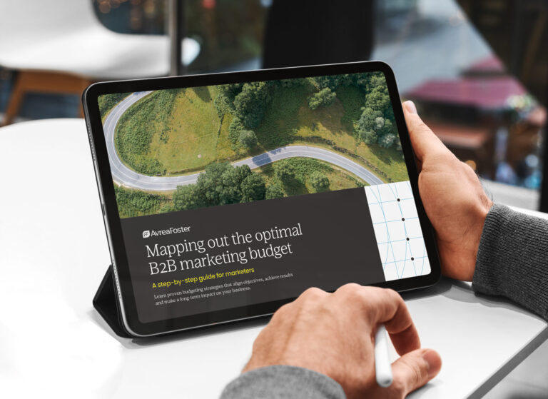 Aerial view of a car driving through a winding road in the forest.