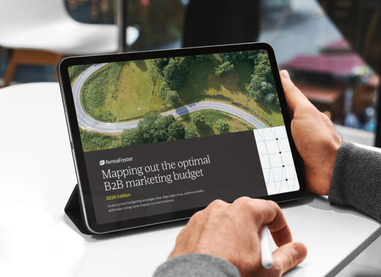 Aerial view of a car driving through a winding road in the forest.