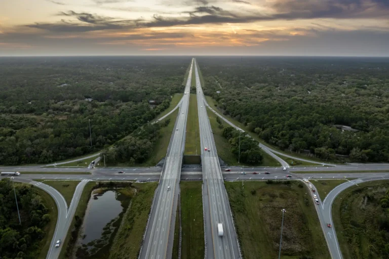 Drone view of two intersecting interstate highways weaving together against a green, rural background.