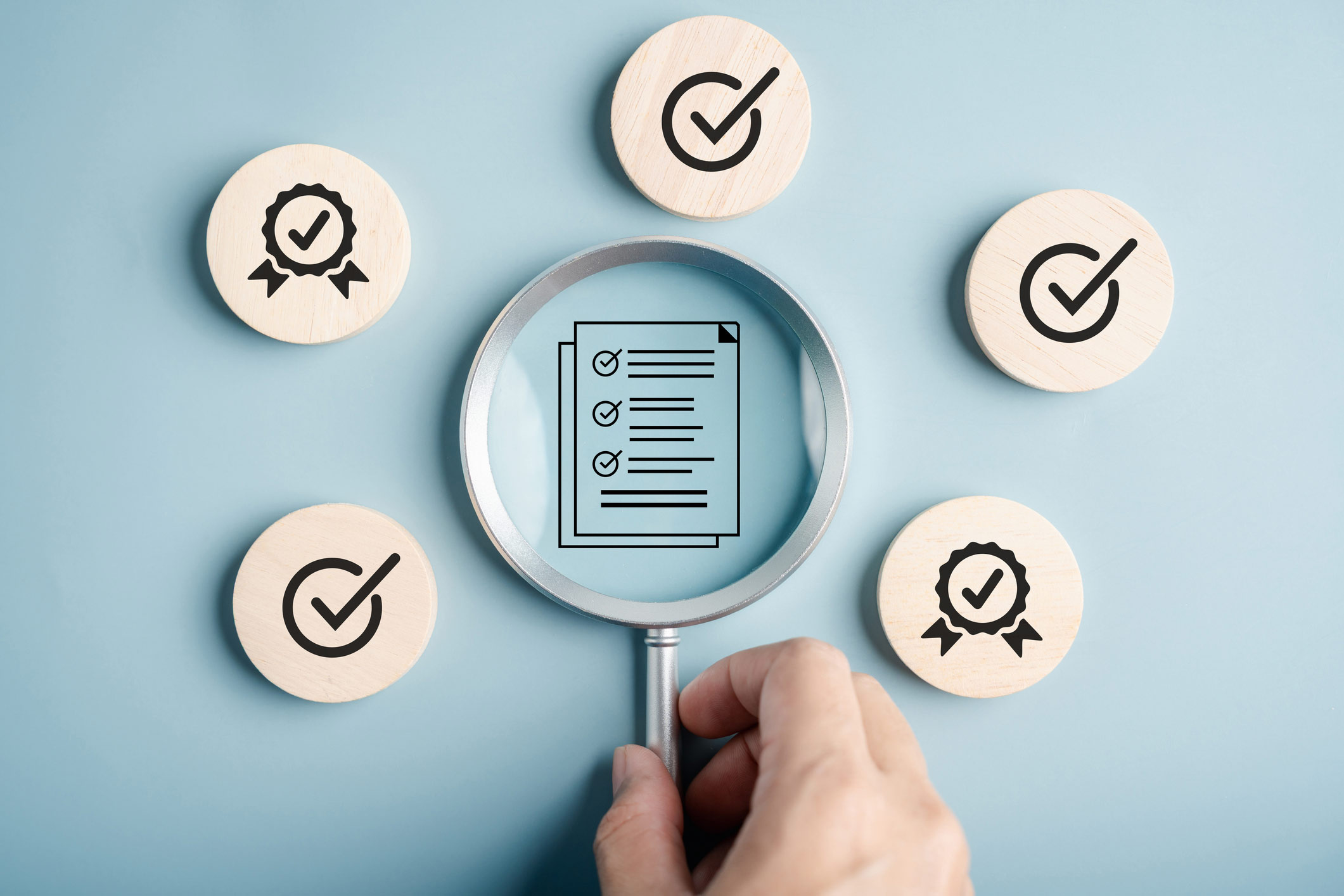 Blue background with five checkmarks over form-like documents encased in circles; a loop hovers over the center element revealing a close up inspection